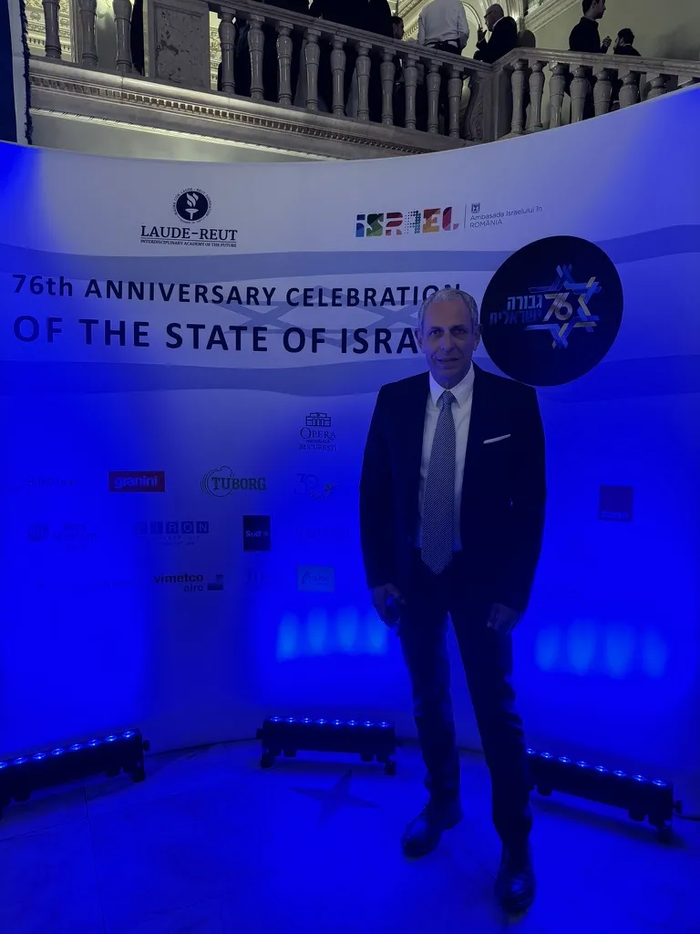 עו״ד אילן ליבוביץ עומד מול קיר האירוע של חגיגות 76 שנים למדינת ישראל